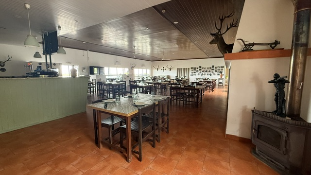 Sala de refeições do O Capote, com lareira e testas de veado